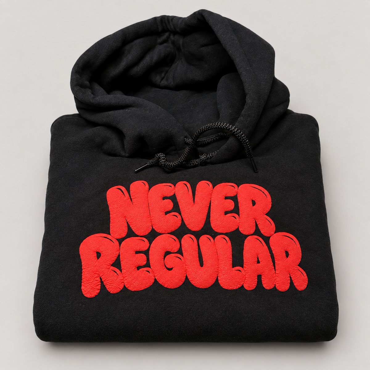 Never Regular black hoodie with raised red puff print